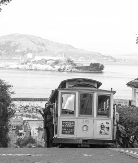 hyde street cable car with san francisco bay and alcatraz in the background, san francisco, california