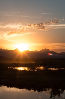 desert sunset behind mountains and lake, sierra estrella, wild horse pass casino, chandler, arizona