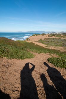 family shadows across san dunes and blue ocean at fort funston, san francisco, california