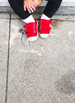 toddler red sneakers on a city sidewalk, san francisco